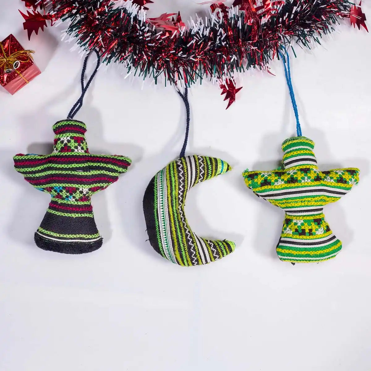 Vindigo assorted green tribal embroidered ornaments displayed under garland