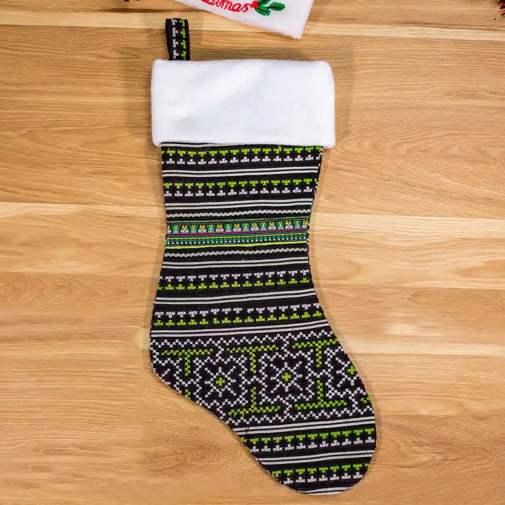 Vindigo hand-embroidered green Christmas stocking front on wooden background
