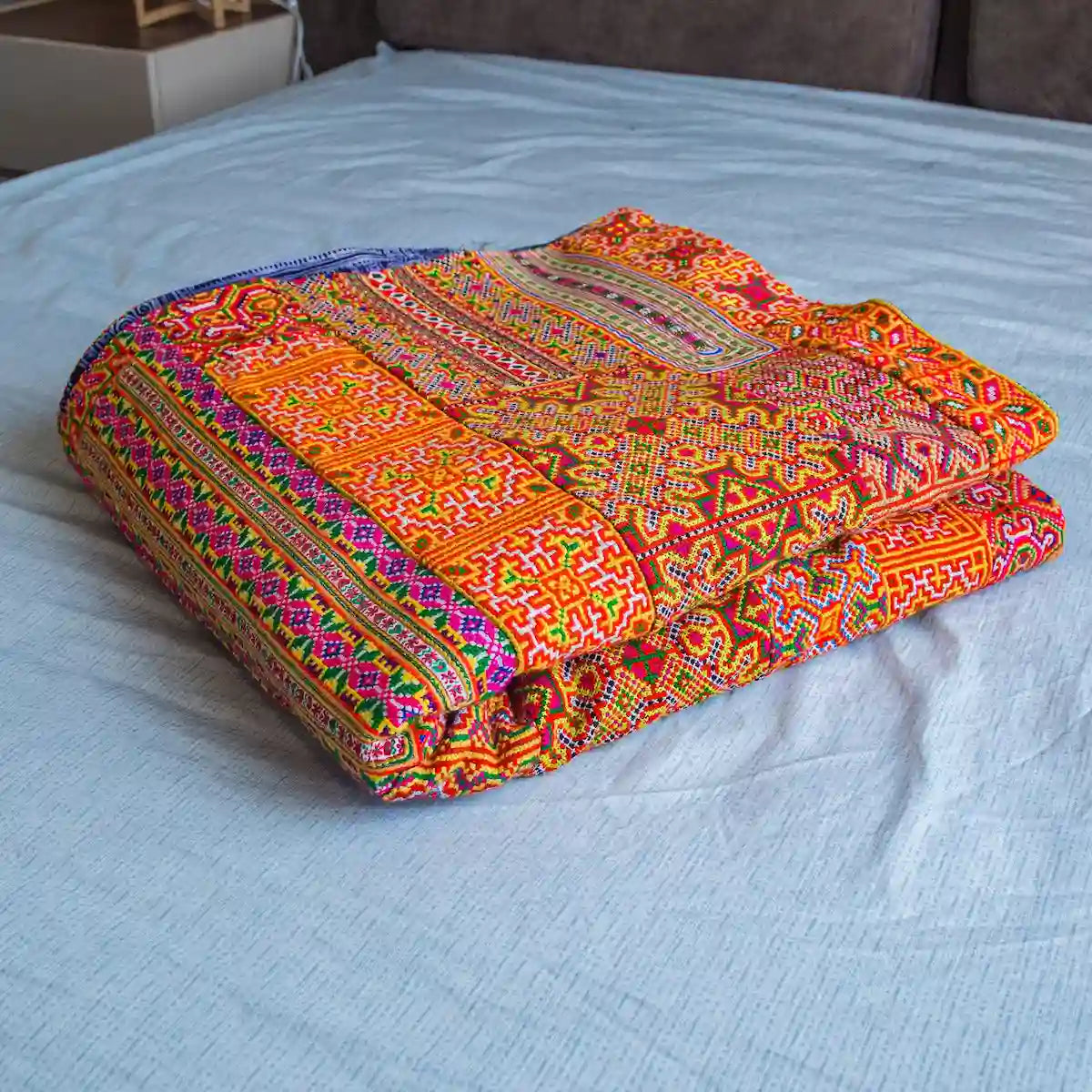 Vindigo handmade orange tribal embroidered fabric folded on display