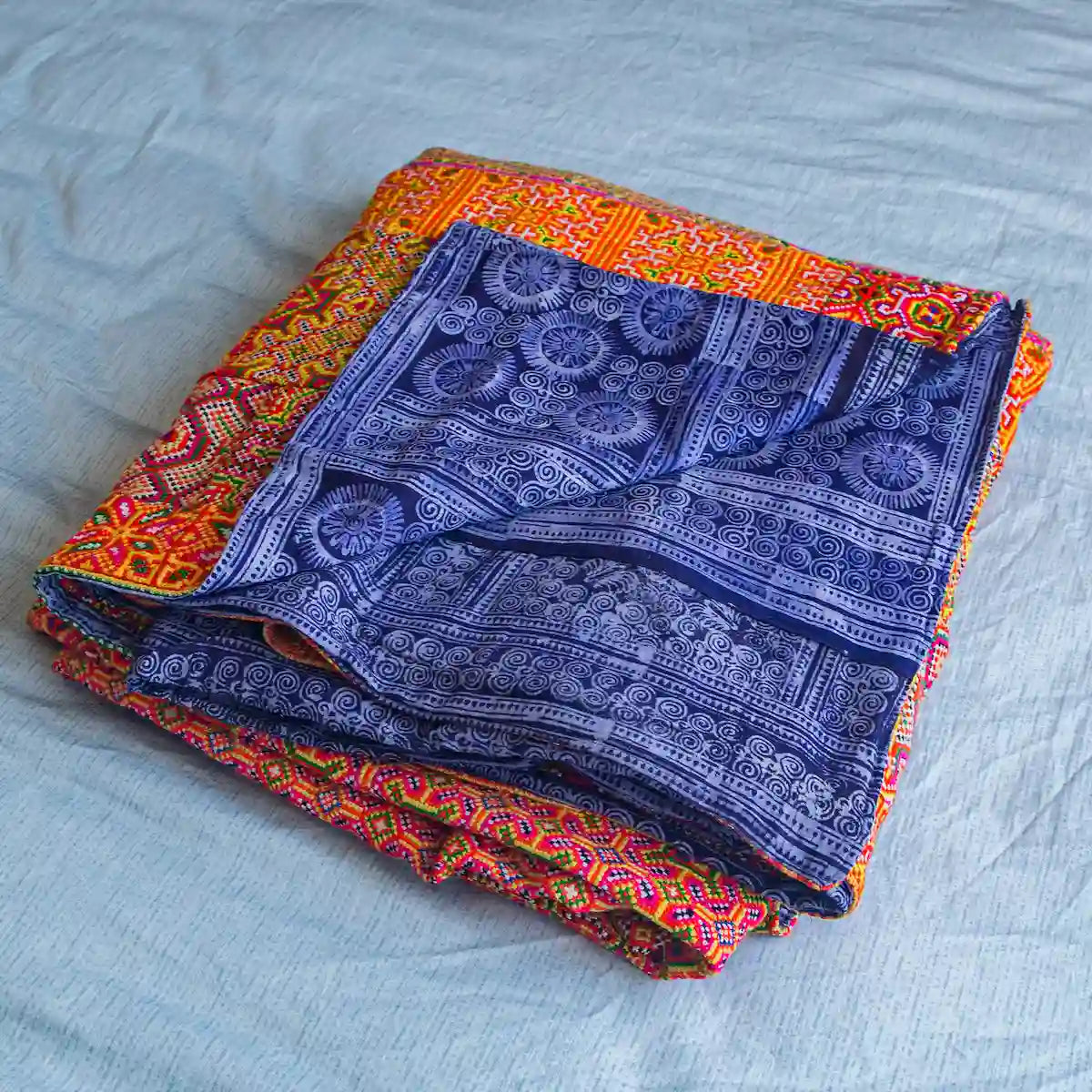 Vindigo reversible orange and indigo cotton bed cover folded with both sides shown
