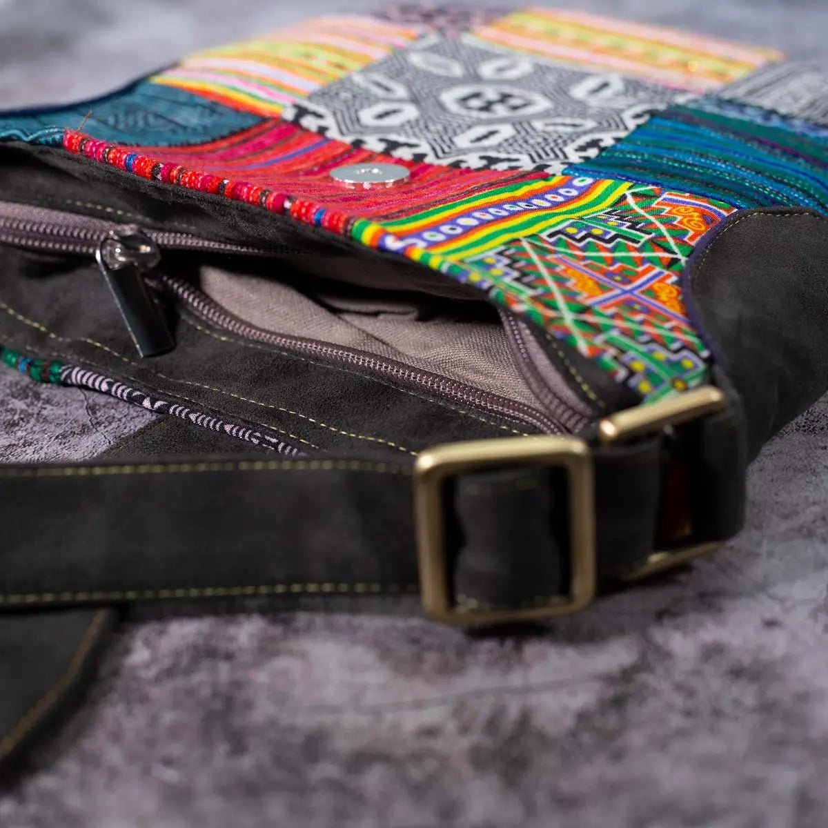 Vindigo crossbody bag close-up showing adjustable faux leather strap buckle