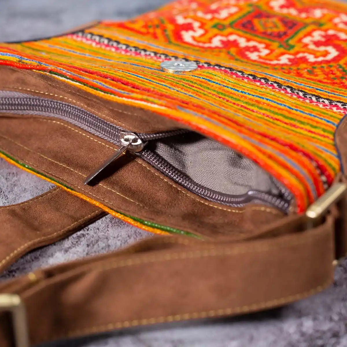 Vindigo orange hemp crossbody bag zipper and strap close-up with brown buckle