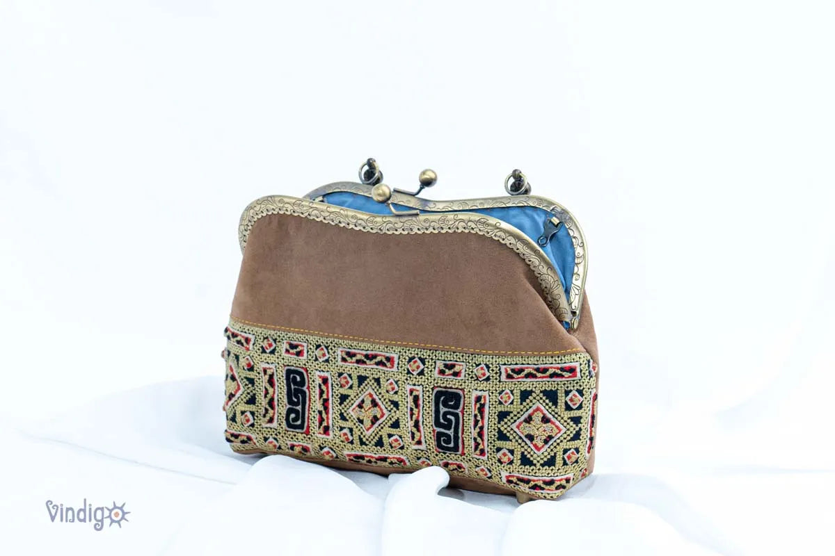 Vindigo handbag side view with curved copper frame and embroidery