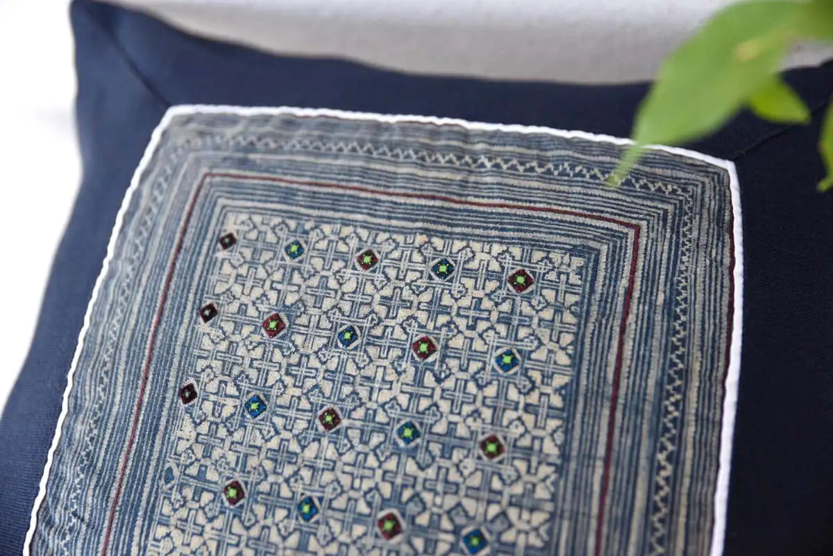 Close-up of vintage-inspired embroidery on indigo hemp cushion