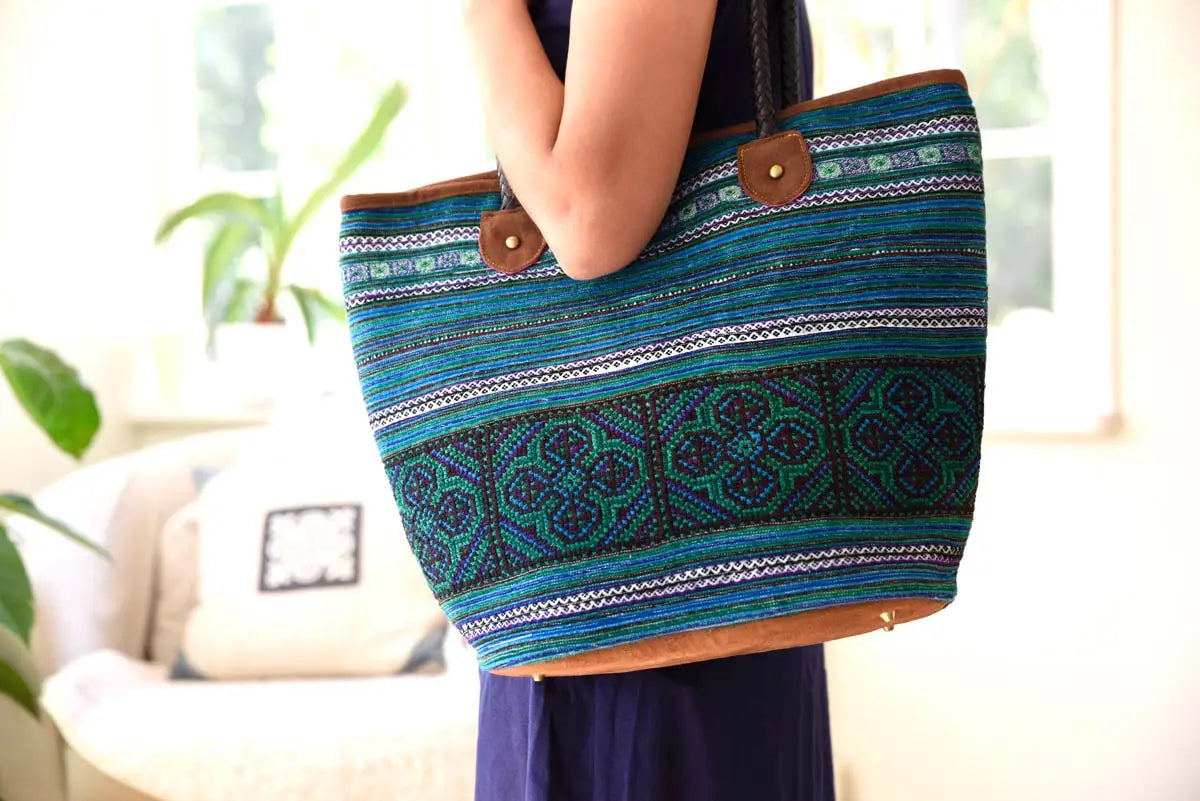 Woman holding blue hemp tribal tote by the straps
