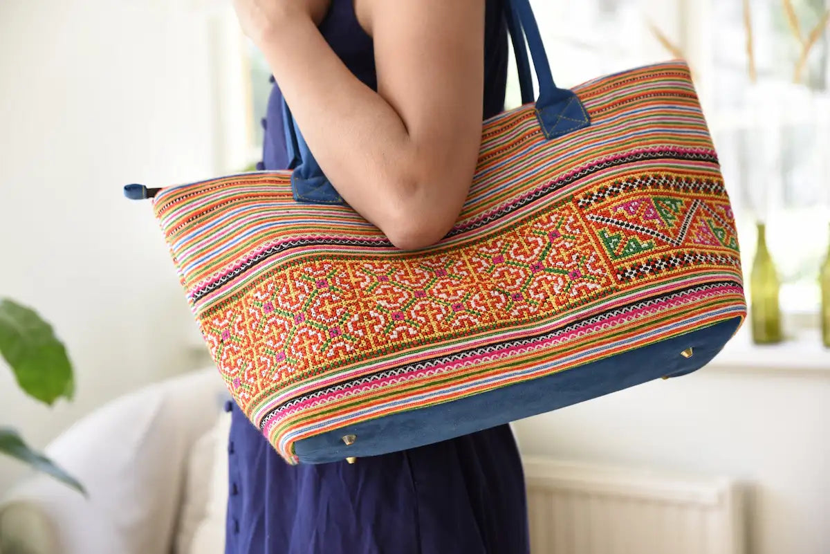 Vindigo tote bag made from orange cotton tribal embroidered fabric carried by model