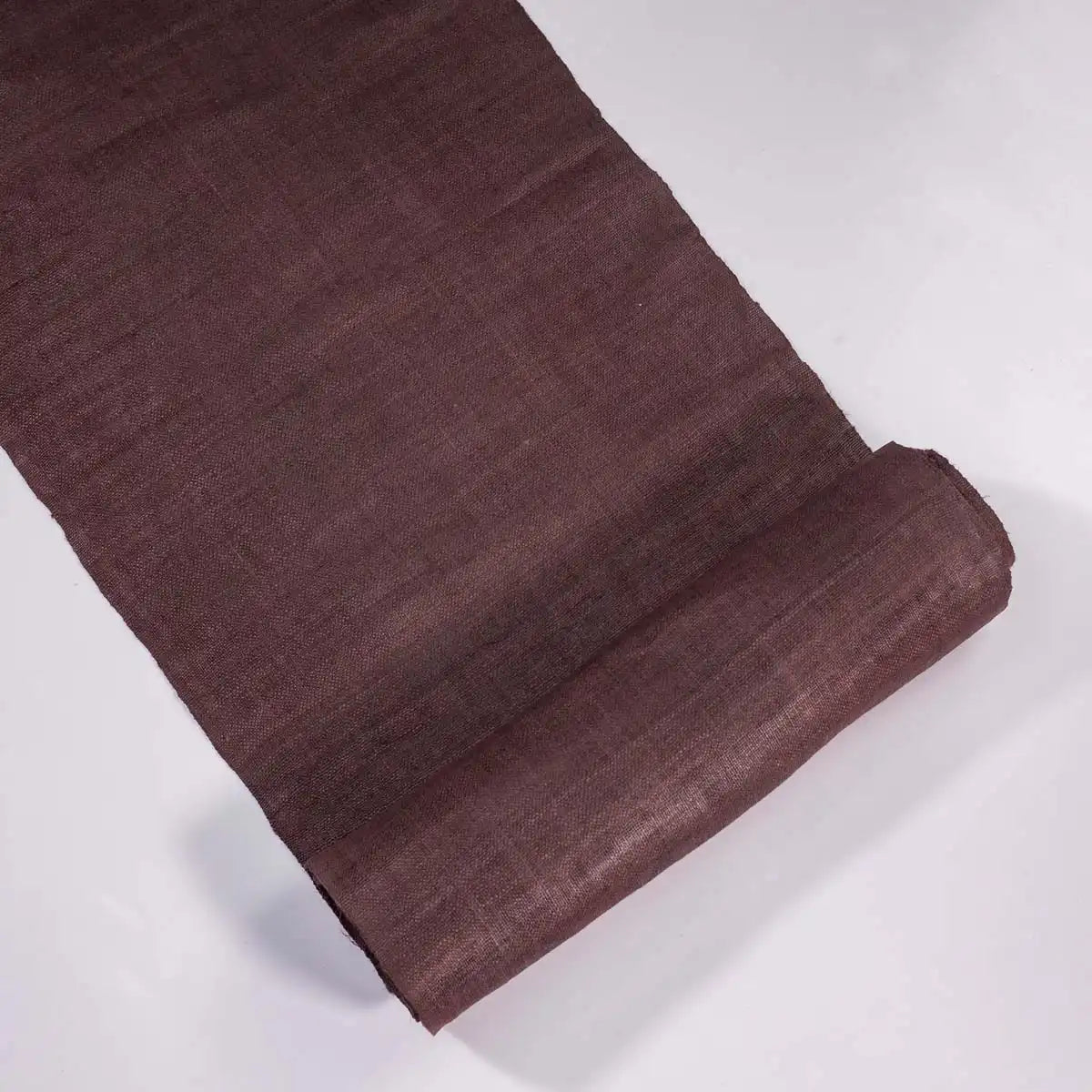 Vindigo plain brown hemp fabric unrolled on white background