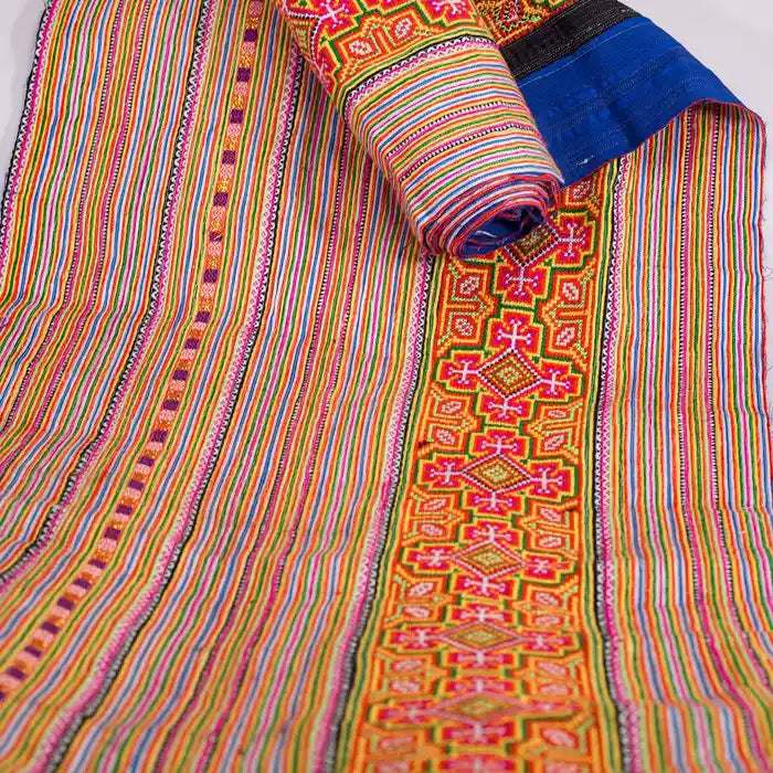 Vindigo orange cotton tribal embroidered fabric partially rolled side view