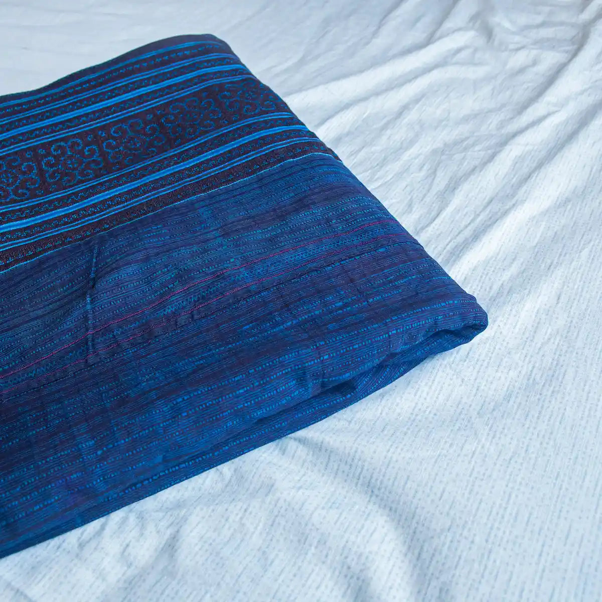 Vindigo indigo cotton bed cover folded showing hand-drawn batik design