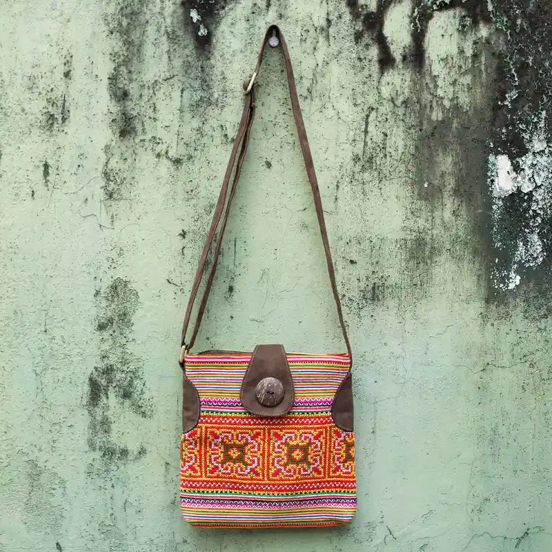 Vindigo orange hemp crossbody bag hanging front view against wall background