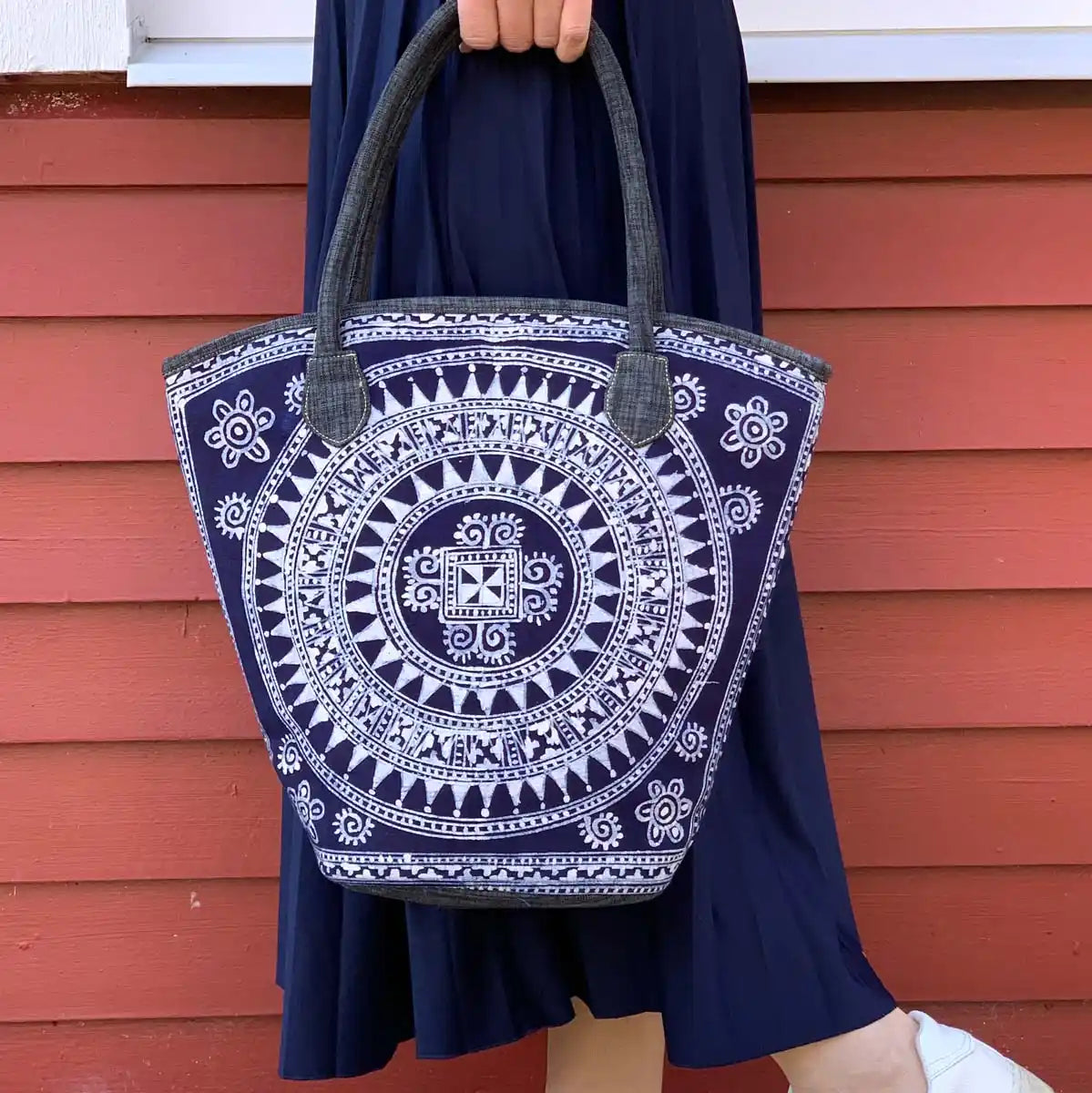 Vindigo batik tote held by model against red wall