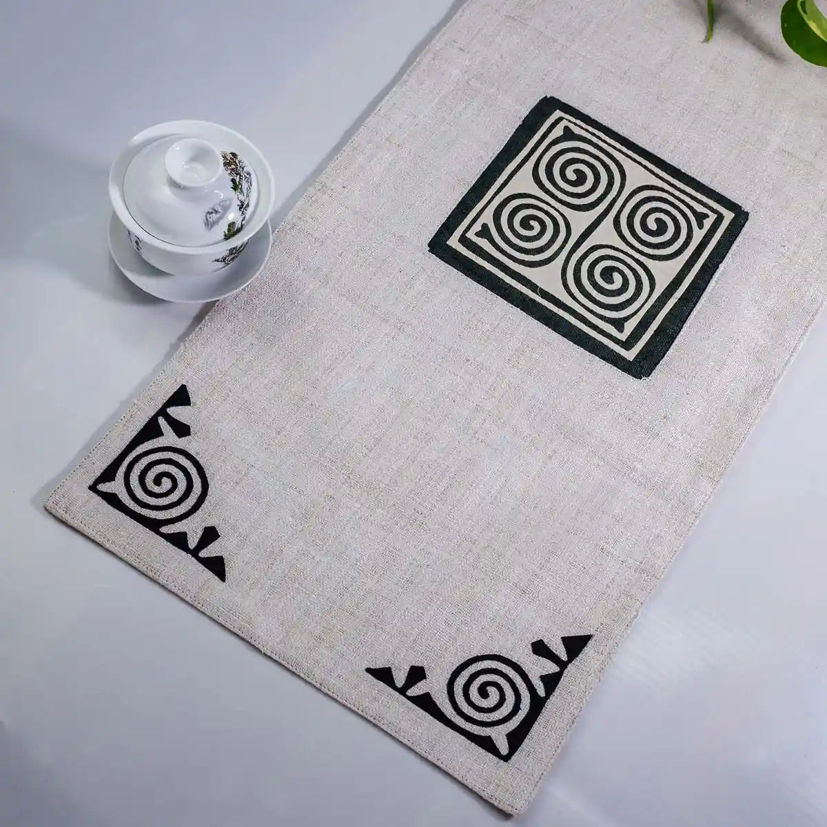 Vindigo beige hemp table runner close-up showing alternating spiral embroidery