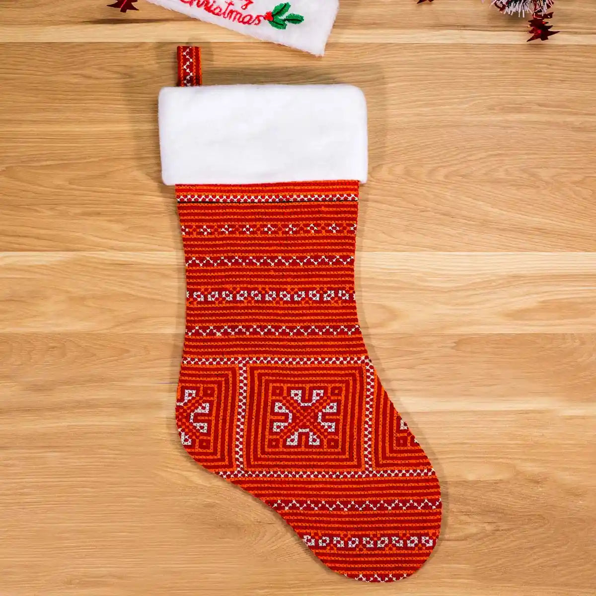 Christmas stocking on wooden floor, red Nordic knit design