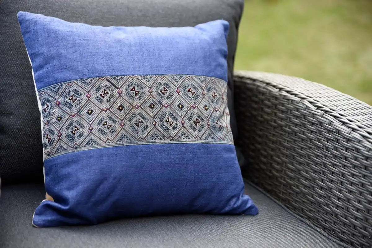 Blue cushion with embroidered strip on garden chair