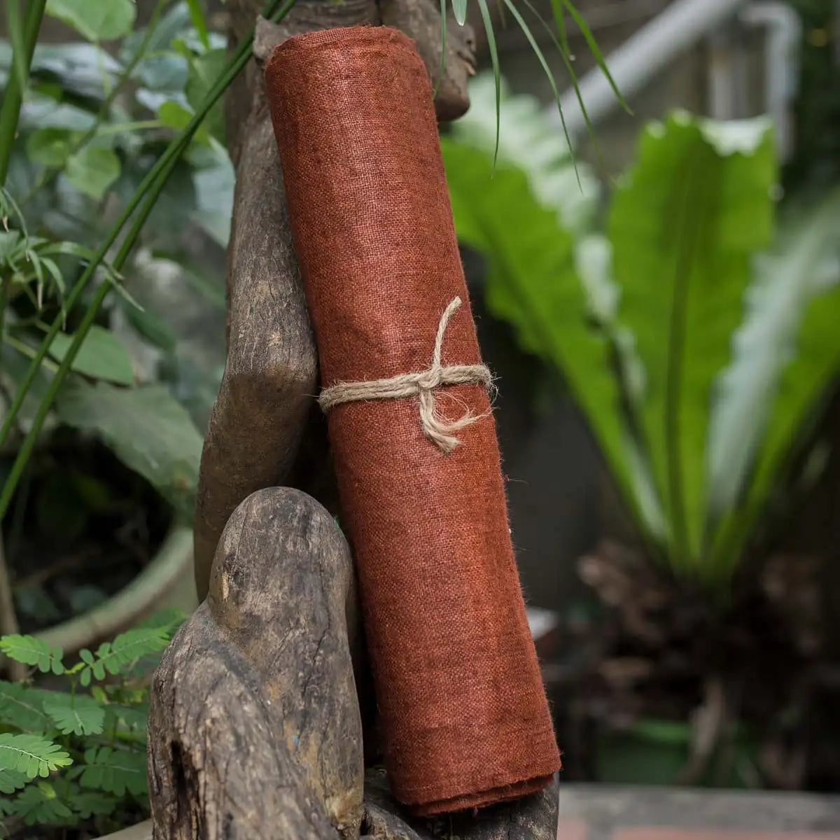 Vindigo orange hemp fabric roll styled in outdoor natural scene