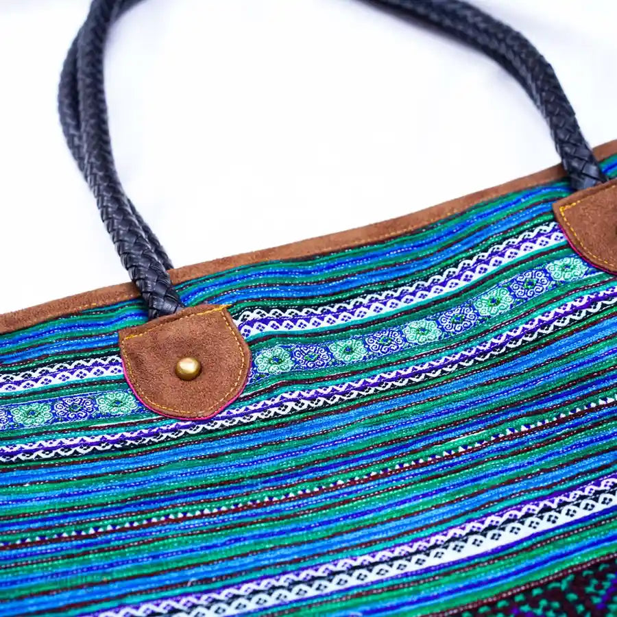 Detail of brown leather handle on blue tribal hemp tote