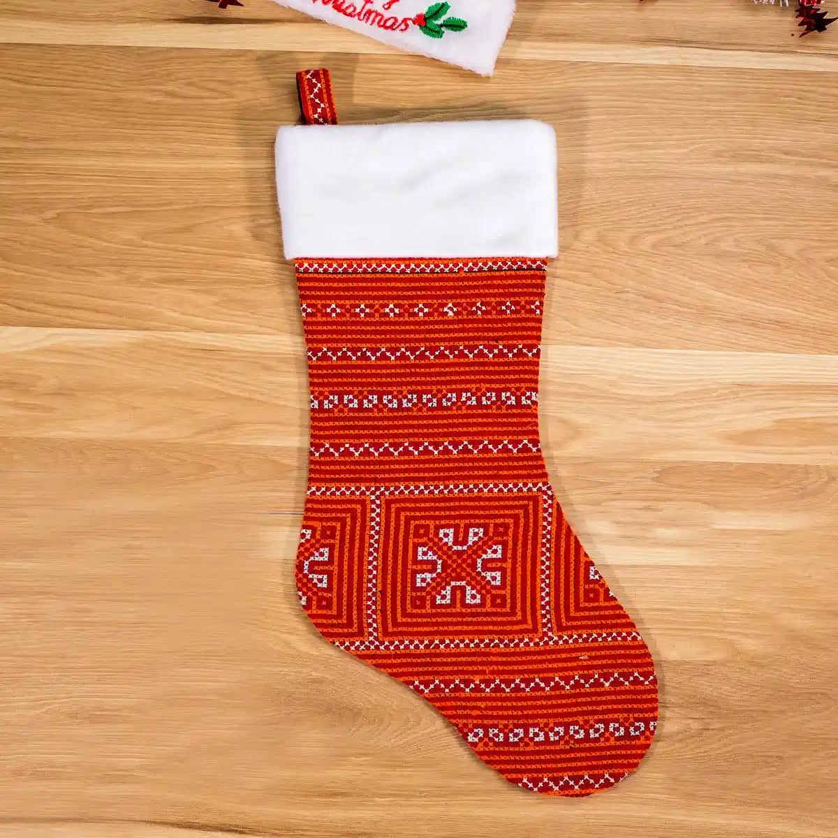 Red stocking with white cuff and flower knit, floor view