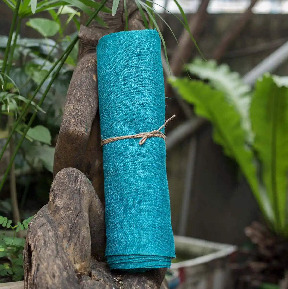 Vindigo turquoise hemp fabric roll styled in natural outdoor scene