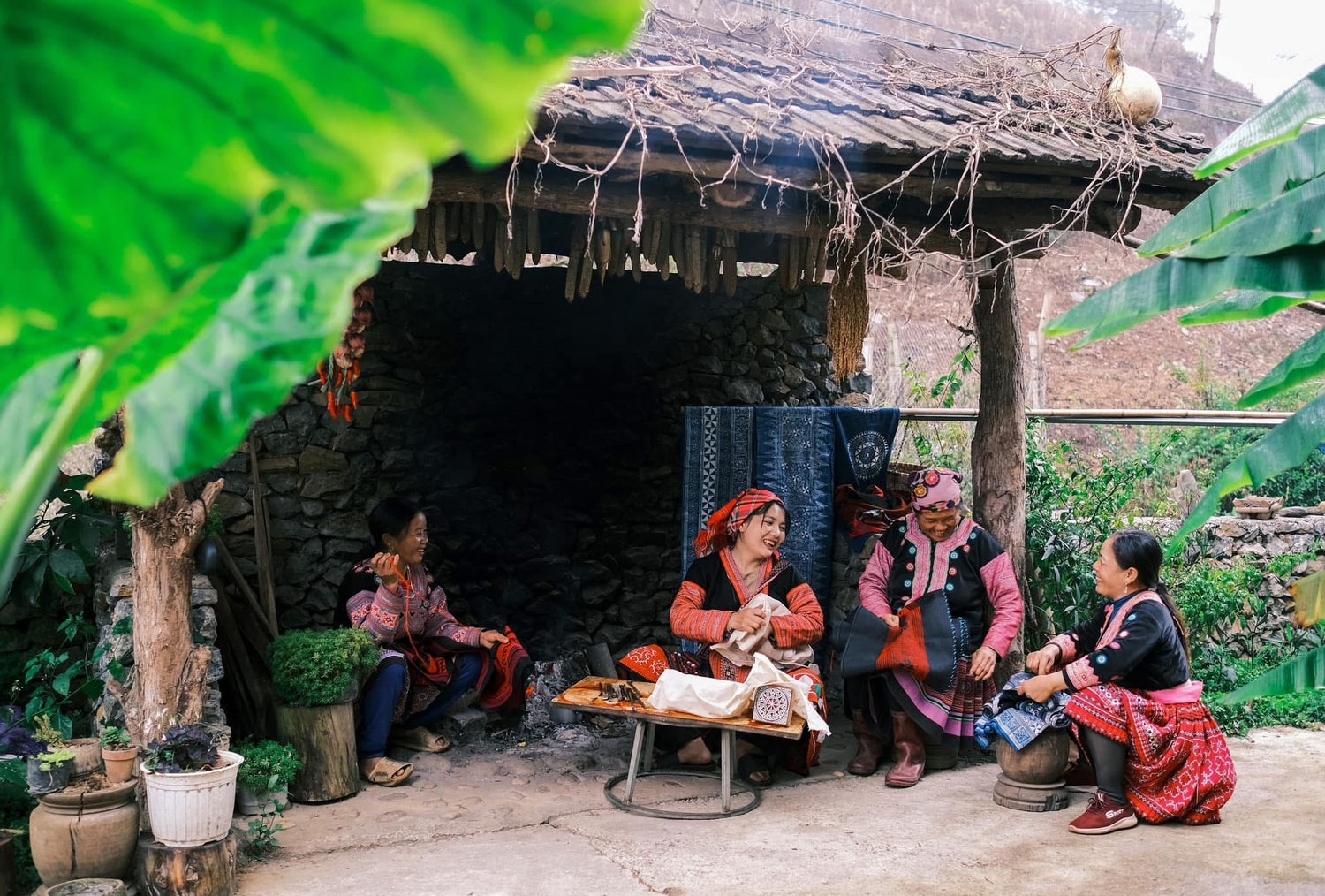 Traditional attire of a woman in a rustic setting with greenery.