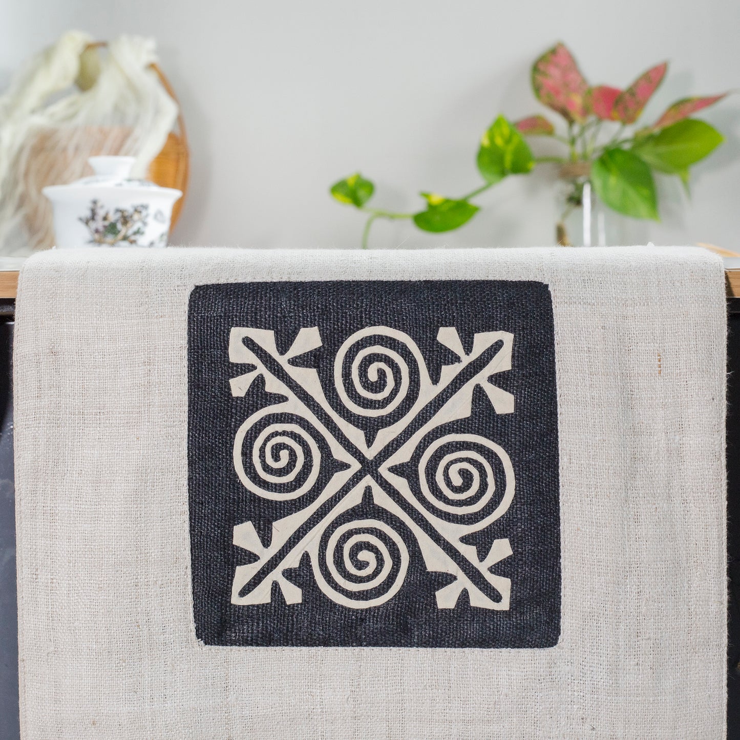 White Hemp Table Runner, white patch on black background, spiral patches in pink and black at two ends