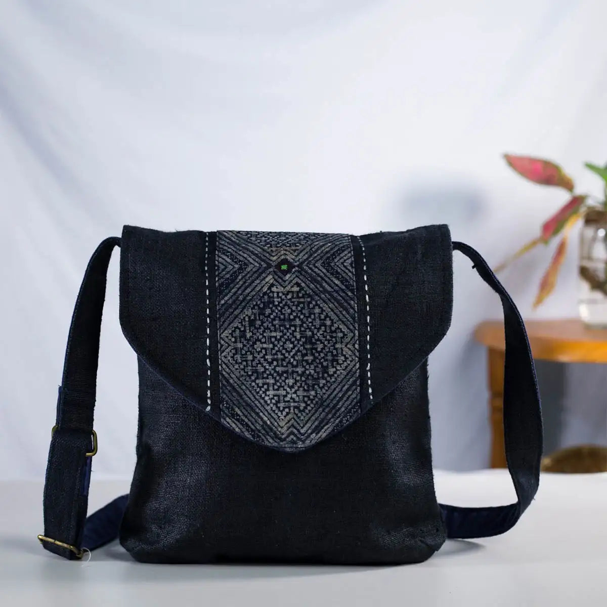 Front view of black hemp crossbody bag with adjustable strap and H’Mong patch, handmade bag.