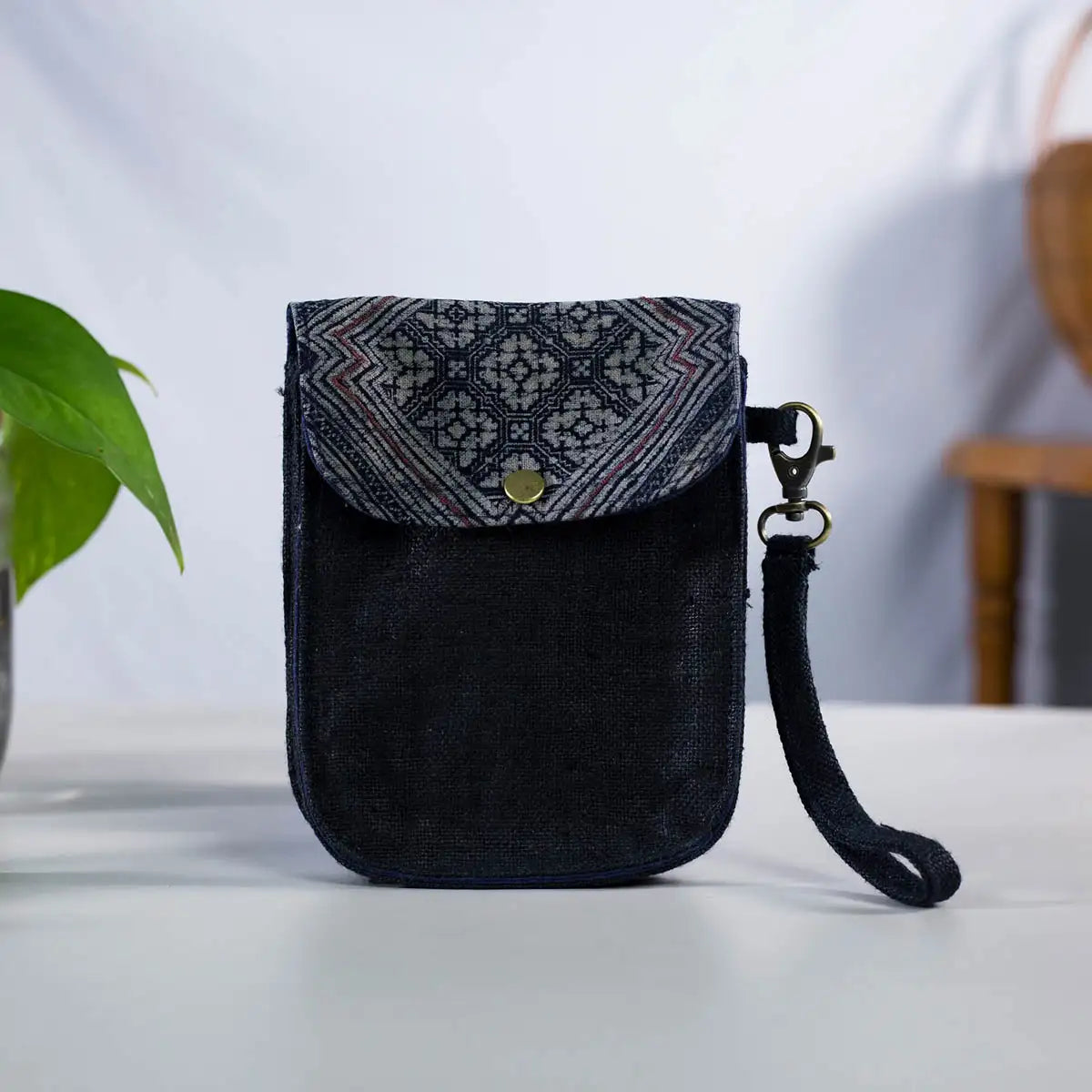 Front view of black hemp flip phone belt bag with H’Mong patch, handmade eco-friendly design.