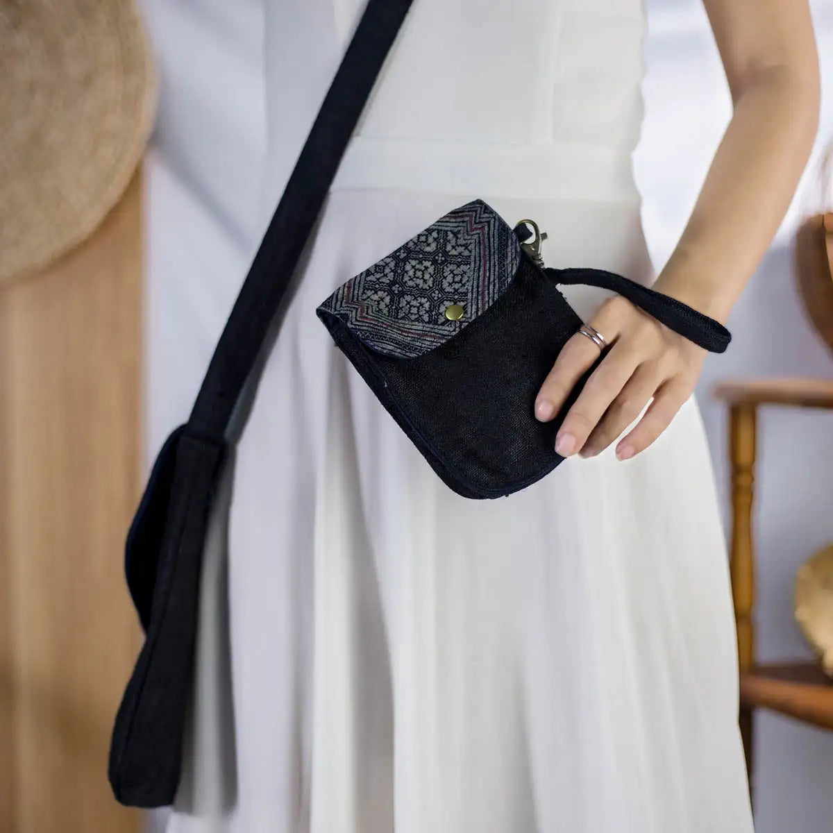 Black hemp flip phone belt bag with H’Mong patch, worn across the waist by model, versatile bag.