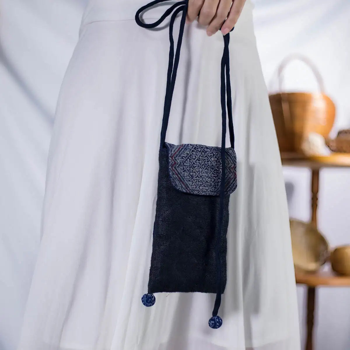 Black hemp phone bag with H’Mong patch, worn across the body by model, eco-friendly and lightweight.