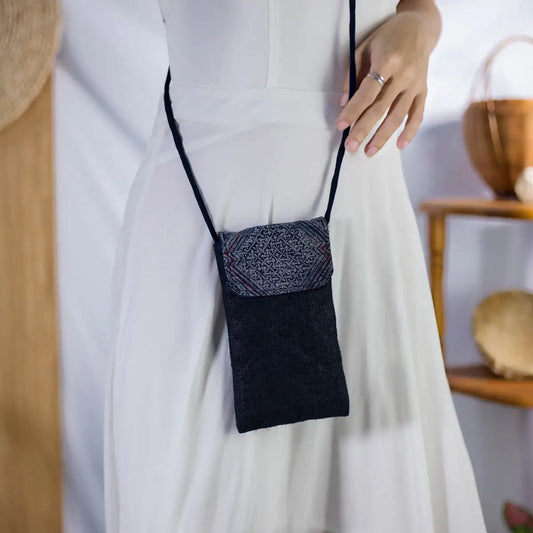 Model wearing black hemp phone bag with long strap and H’Mong patch, sustainable handmade accessory.