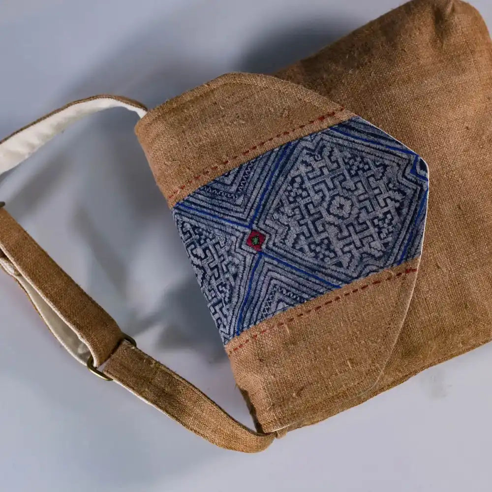 Flatlay of brown hemp crossbody bag with vintage patch, eco-friendly handmade fashion accessory.