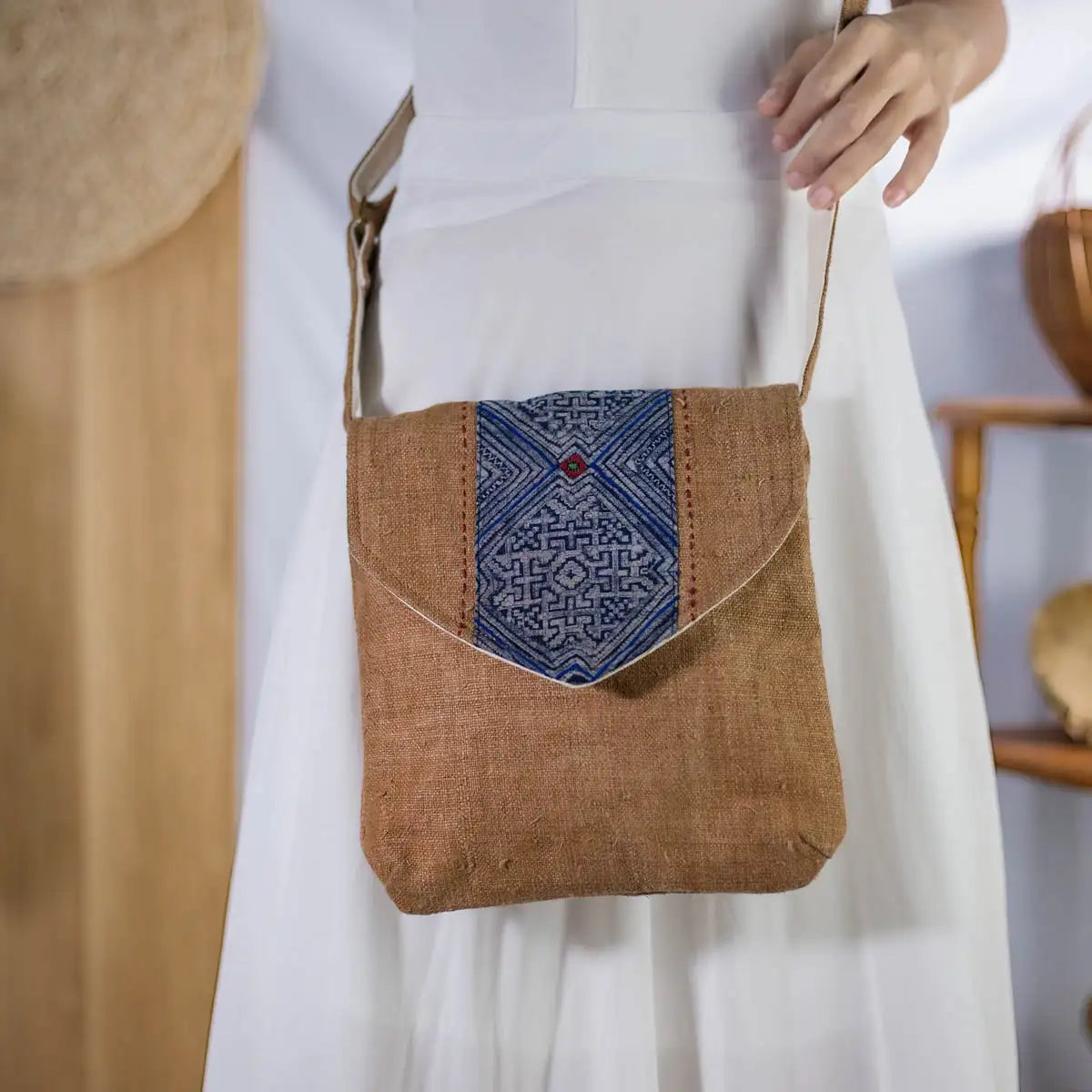 Side view of model carrying brown hemp crossbody bag with vintage patch, sustainable handmade design