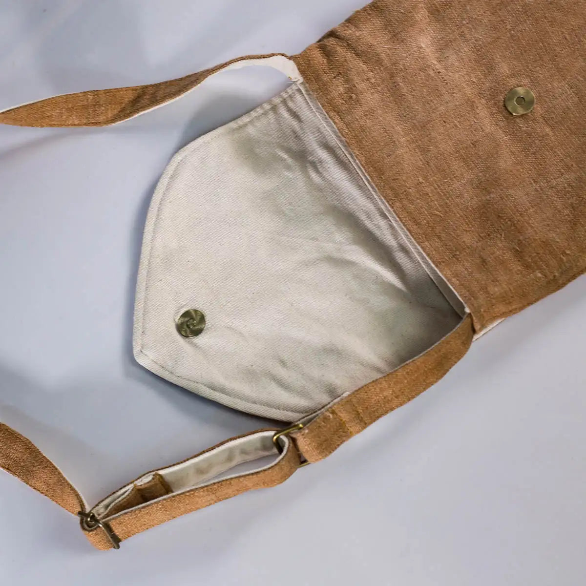 Open brown hemp crossbody bag with vintage patch, showing spacious interior with handmade design.