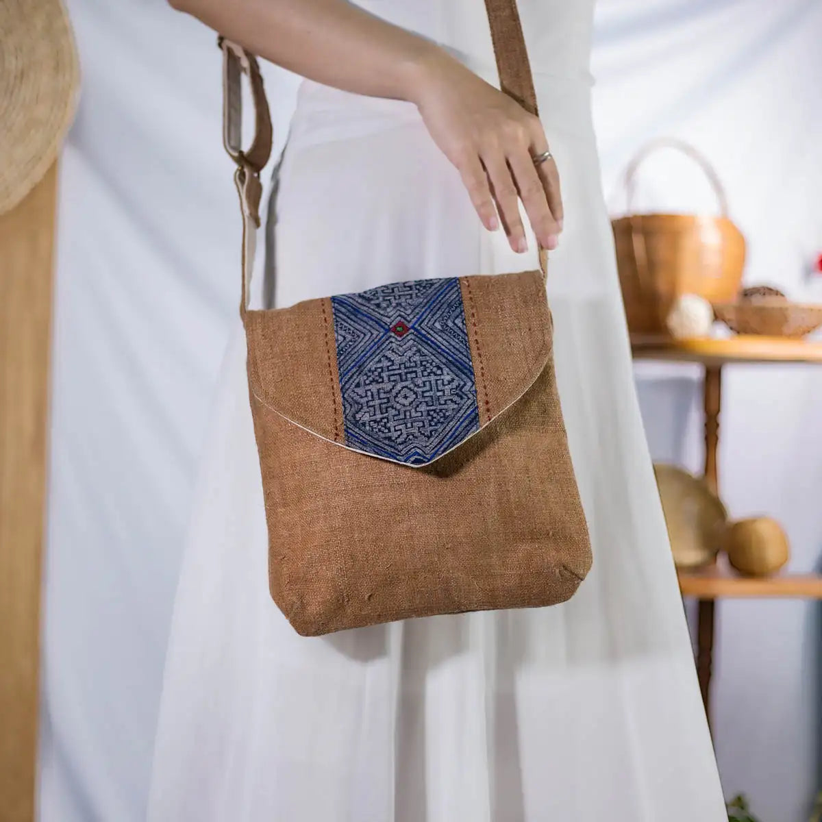 Side view of model carrying brown hemp crossbody bag with vintage patch, sustainable handmade design
