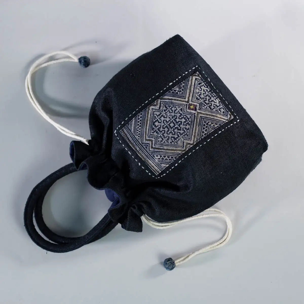 Detail shot of black hemp bucket bag with vintage H’Mong patch and fabric handle