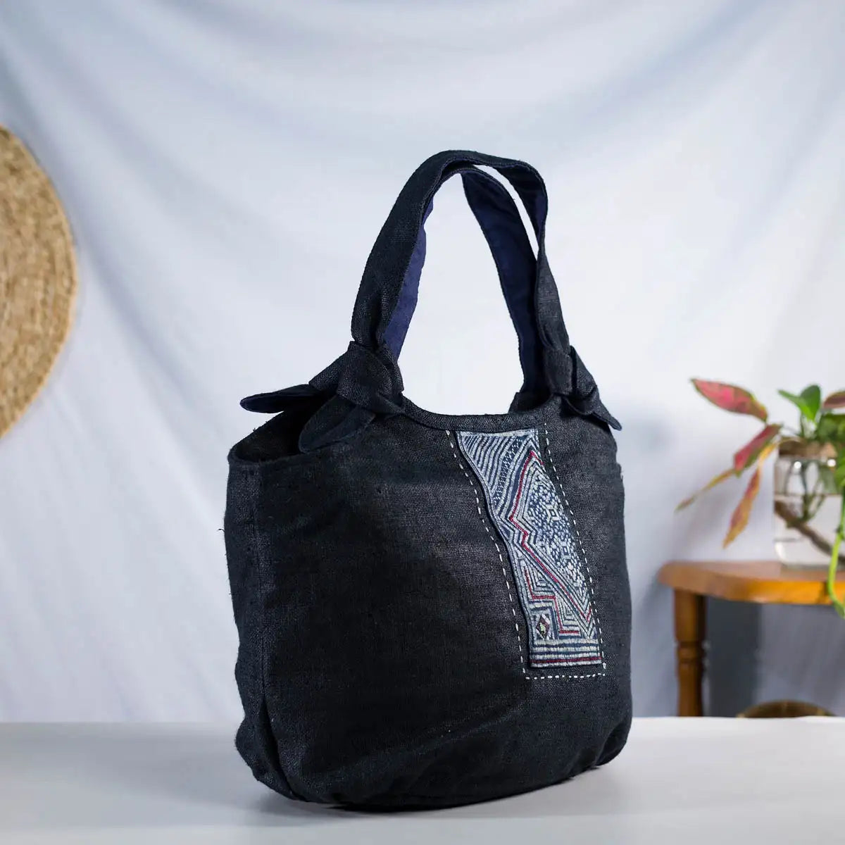 Side view of black hemp bunny ear handbag featuring vintage H’Mong fabric patch, handmade bag