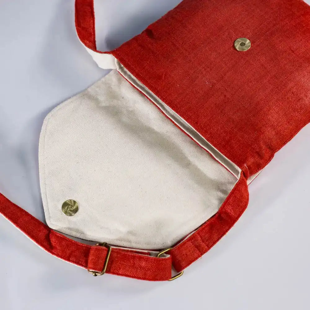 Top view of red hemp cross-body bag with open interior and vintage H’Mong patch detail