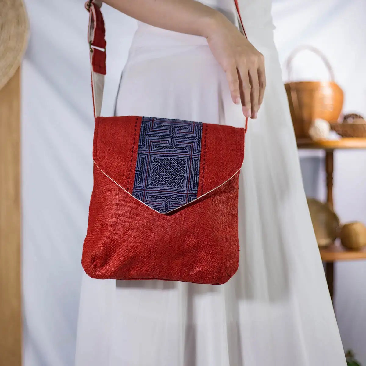 Red hemp cross-body bag worn on shoulder, featuring vintage H’Mong patch, eco-friendly design