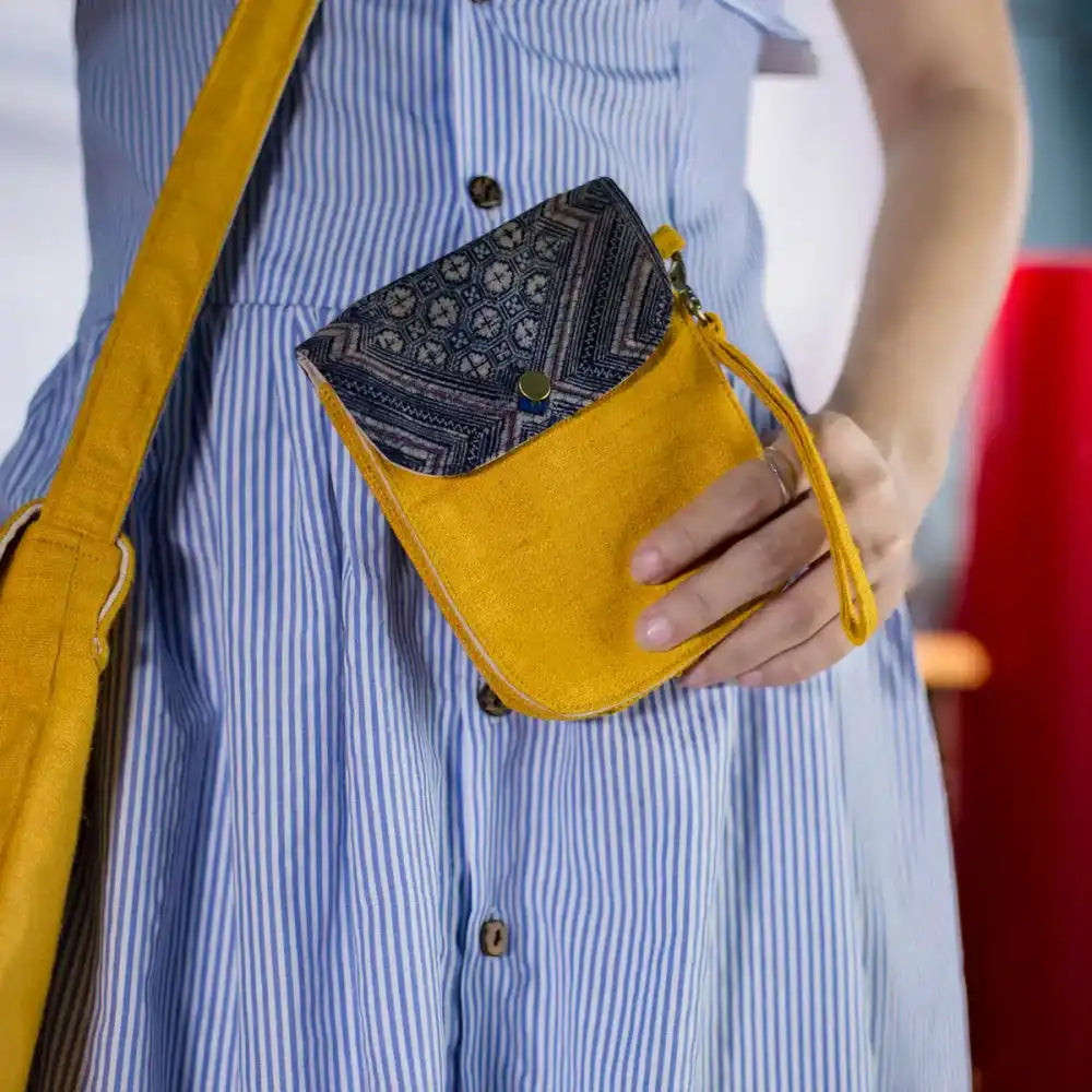 Side view of model with yellow hemp flip phone belt bag and H’Mong patch, handmade eco-friendly.