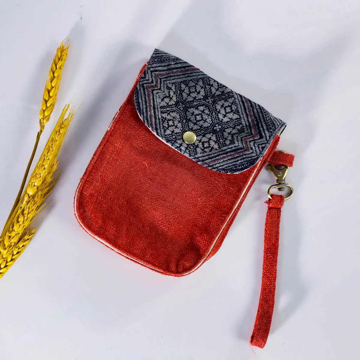 Detail shot of red hemp flip phone belt bag (mobilväska) with vintage H’Mong fabric patch
