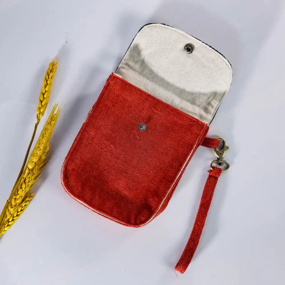 Open view of red hemp flip phone belt bag (mobilväska) showing cotton lining and vintage HMong patch