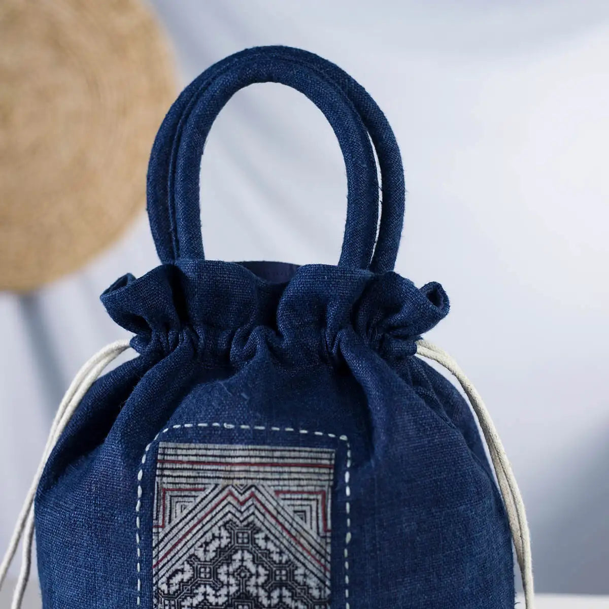 Detailed view of an indigo hemp bucket bag featuring a H’mong fabric patch