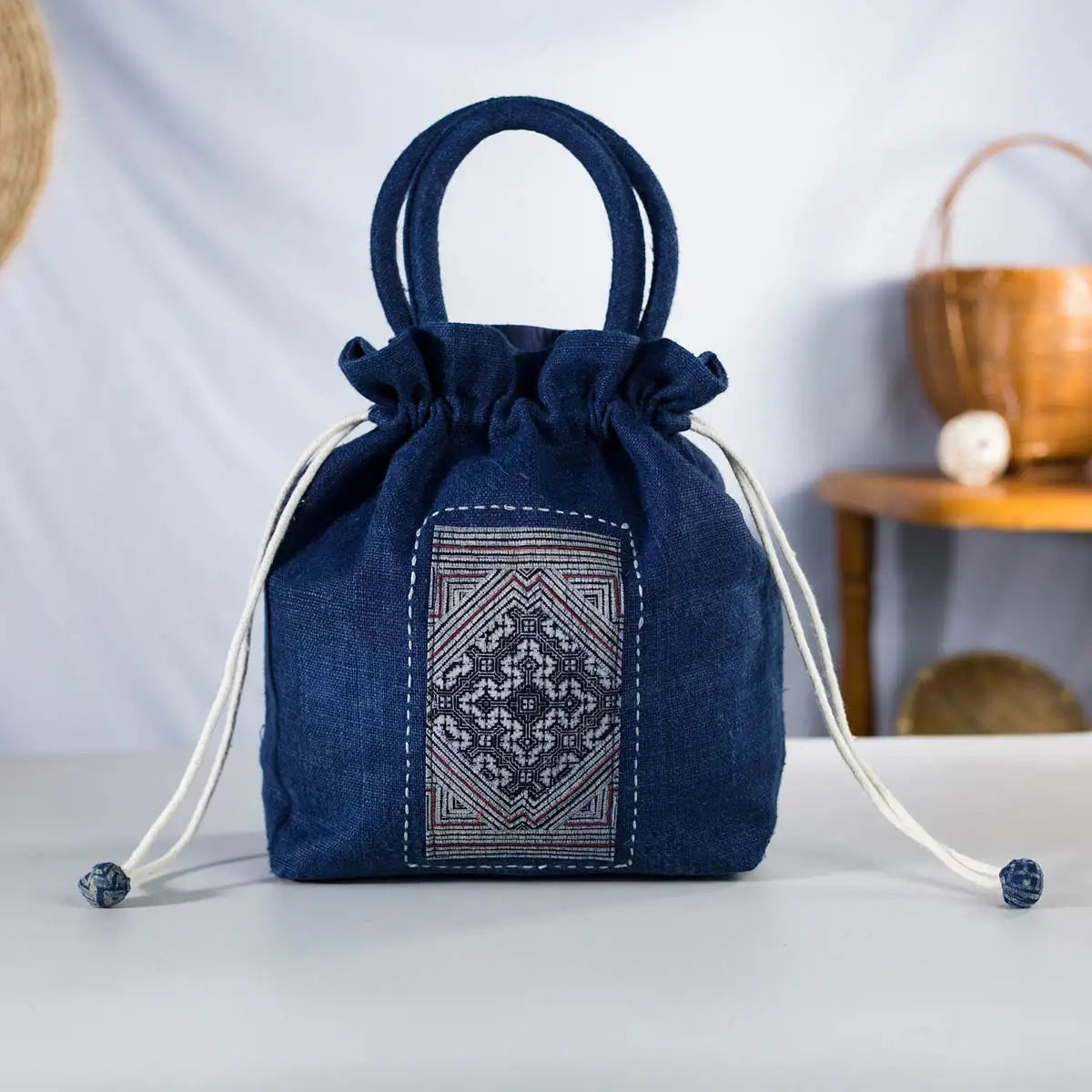 Indigo hemp bucket bag with round handles and H’mong patch, artisan-made eco-friendly handbag.