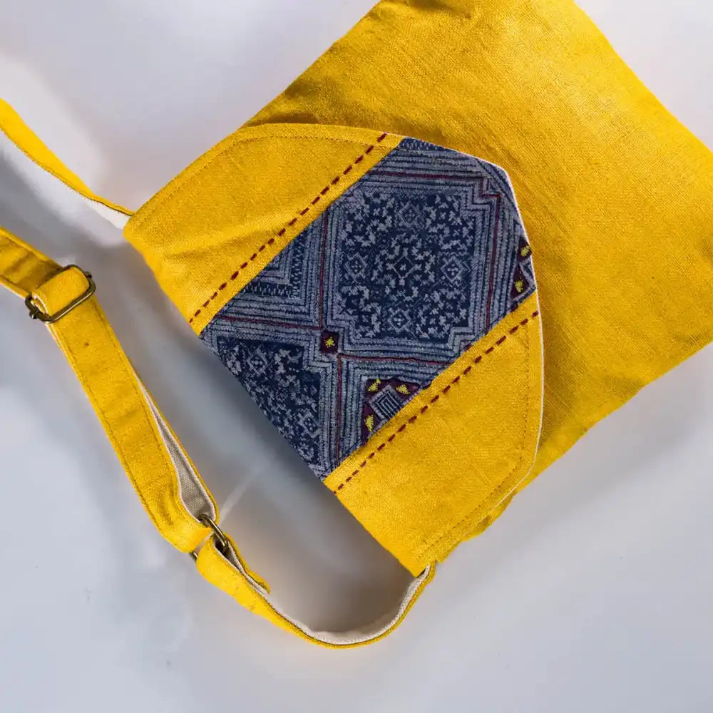 Flat lay Artisan-made hemp crossbody bag in yellow with vintage patch detail 