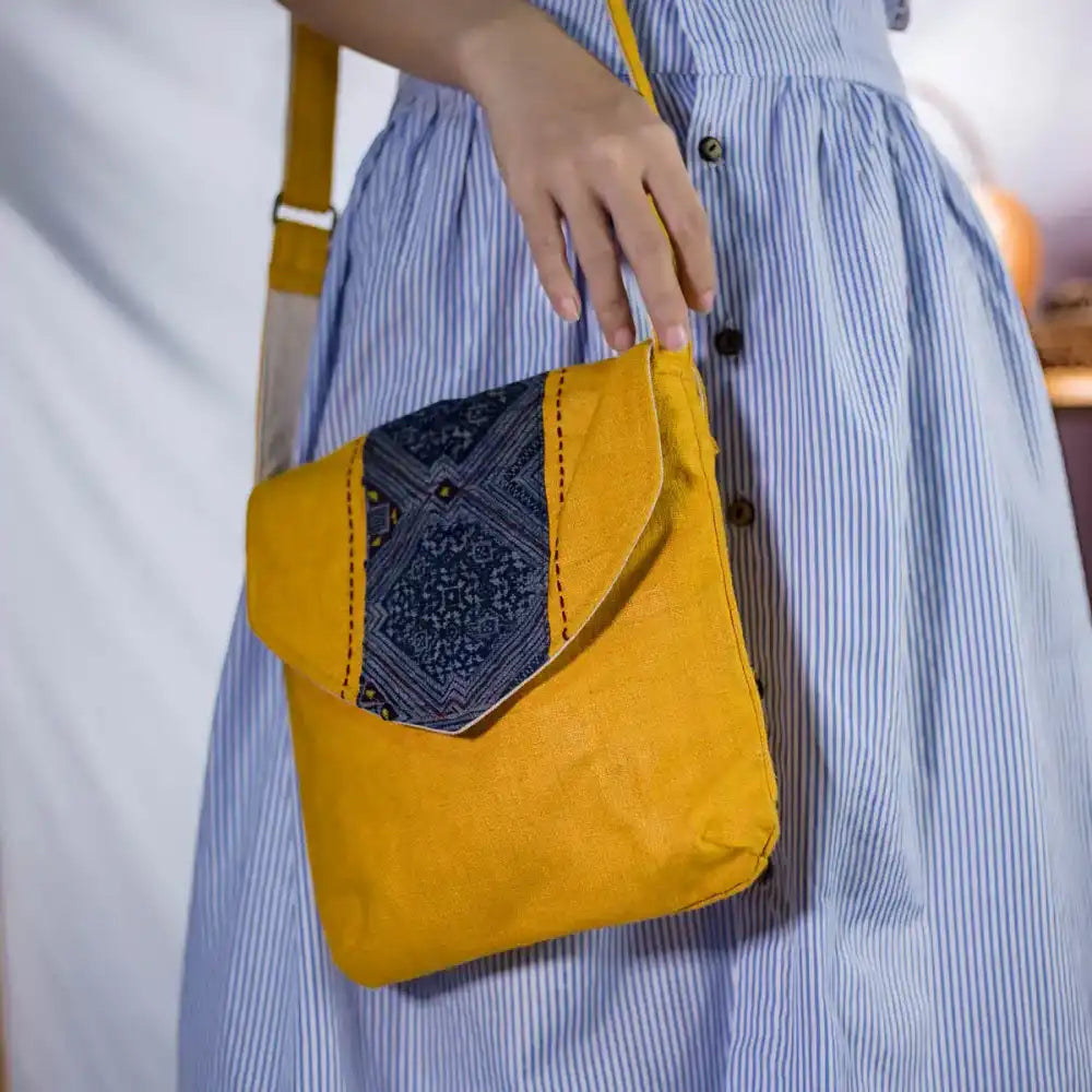 Model wearing sustainable hemp crossbody bag with unique tribal embroidery flap