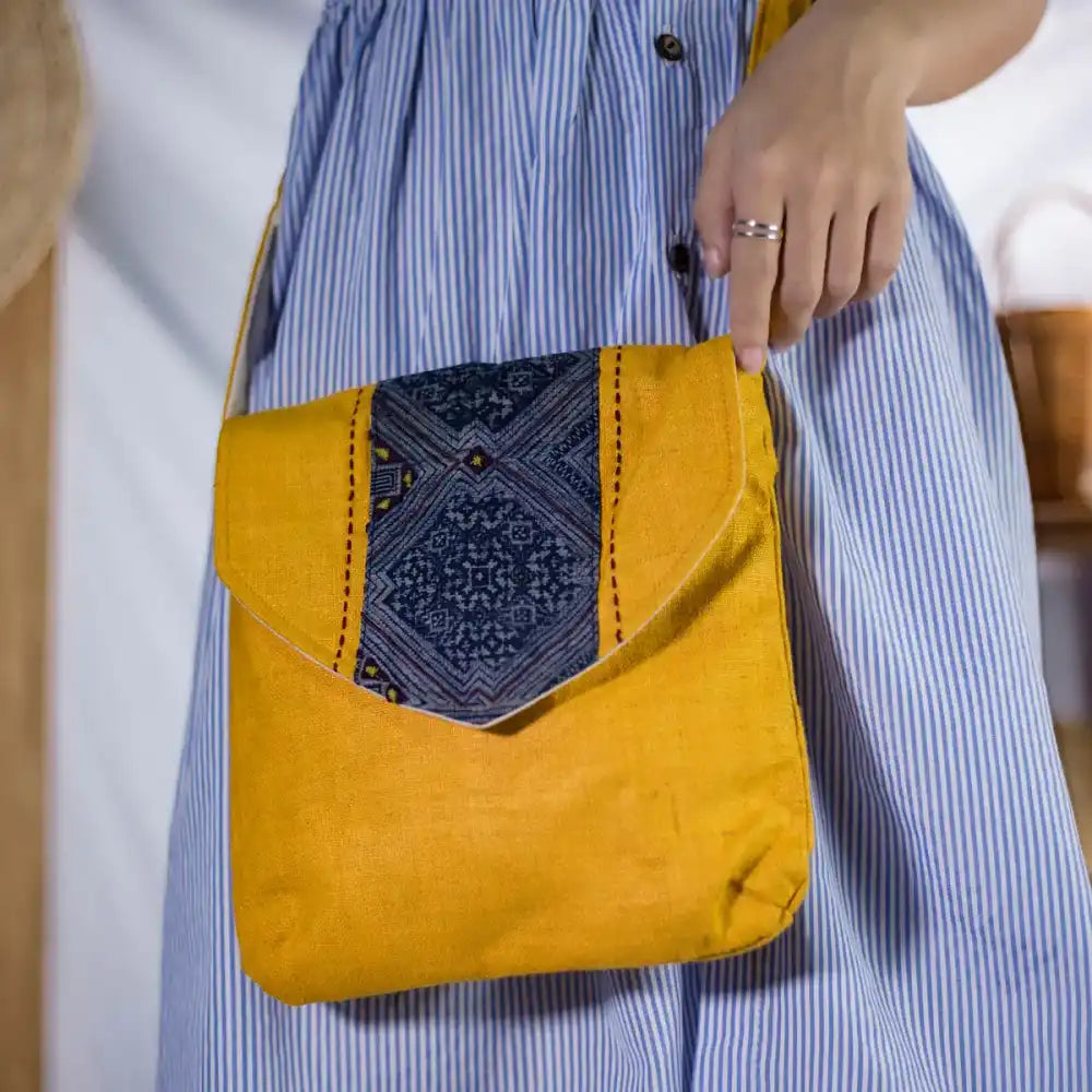 Model carrying handmade hemp crossbody bag with tribal embroidery flap