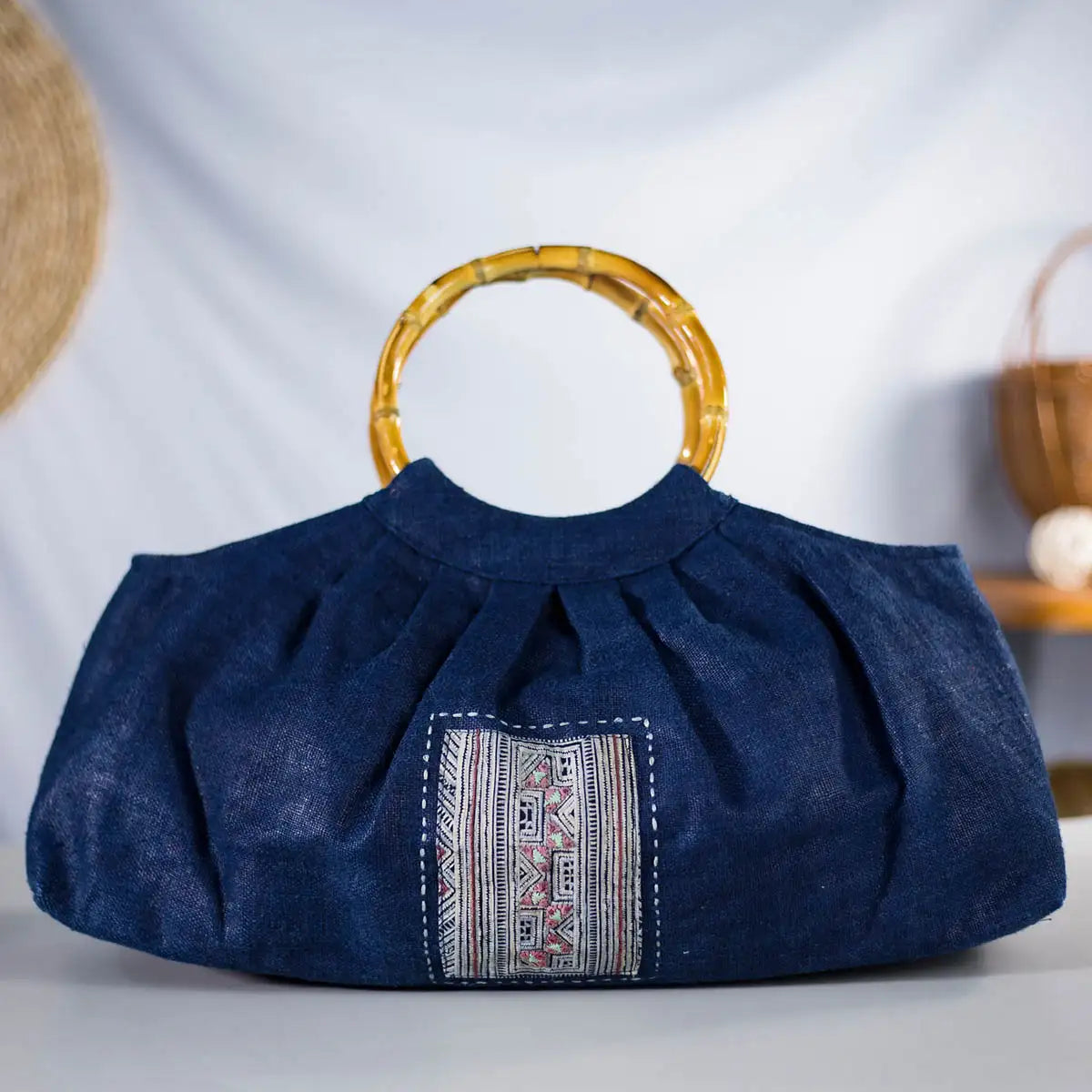 Front display of indigo hemp handbag with bamboo handles and H’mong patch, eco-friendly.