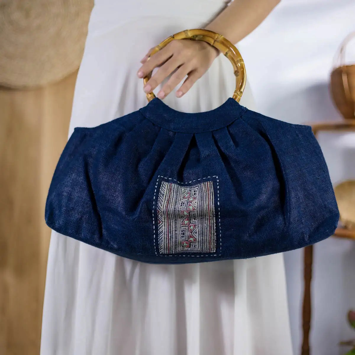 Detail of indigo hemp handbag with sturdy bamboo handles and handmade H’mong fabric accent.