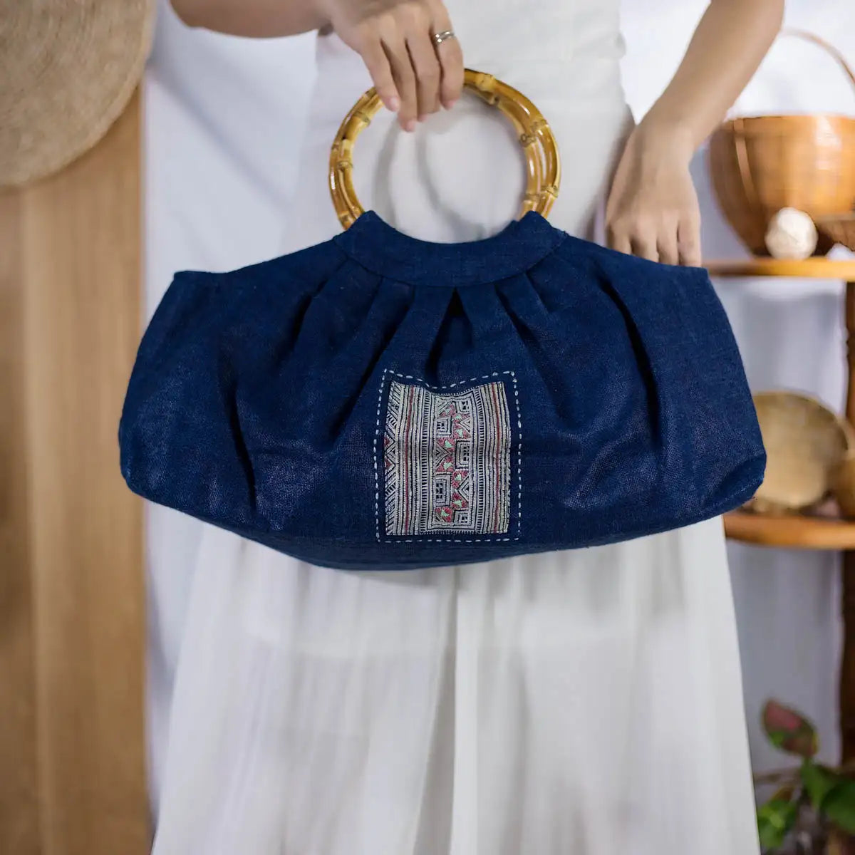 Indigo hemp handbag with round bamboo handles and H’mong patch, artisan-made eco-friendly fashion.