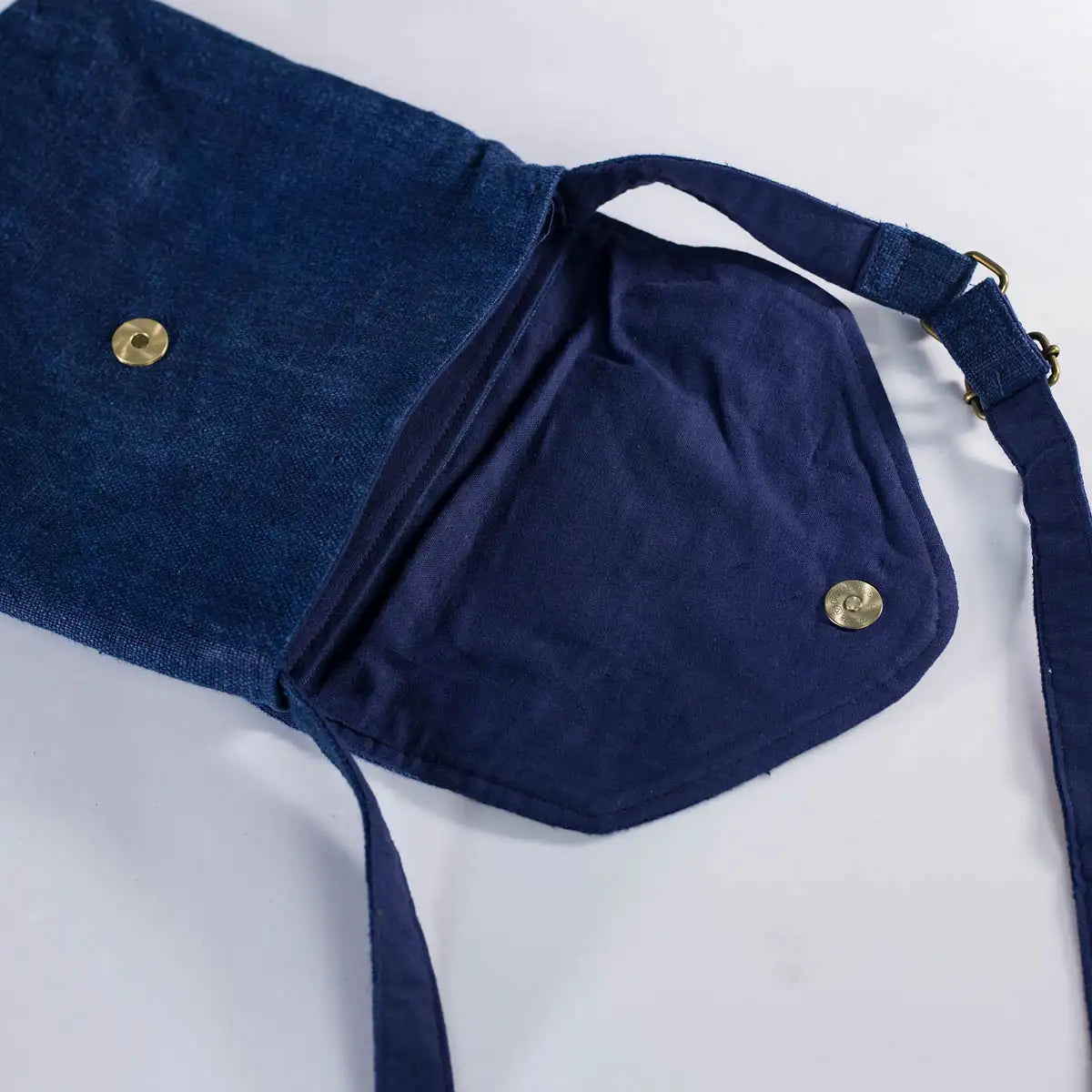 Open view of indigo hemp crossbody bag showing inside and H’mong patch detail, eco-friendly design.