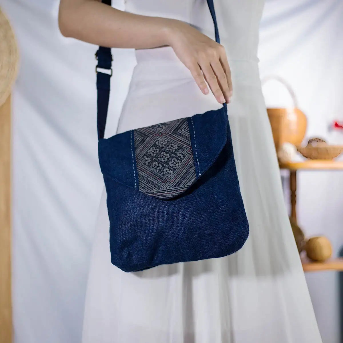 Close-up of indigo hemp crossbody bag with H’mong fabric patch, eco-friendly design.
